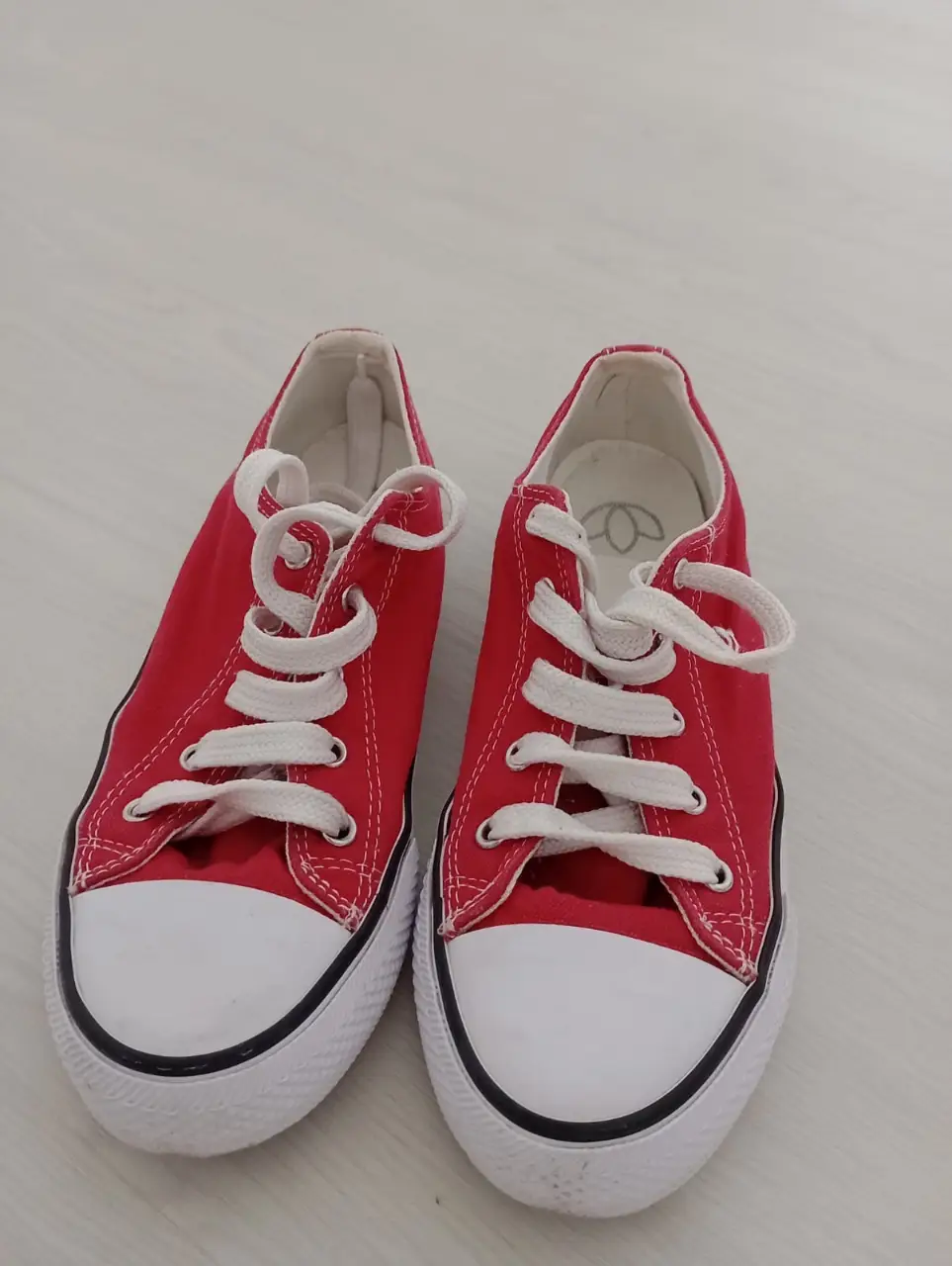 Zapatillas rojas de lona con puntera blanca y cordones blancos. Ideales para un look casual y cómodo.
