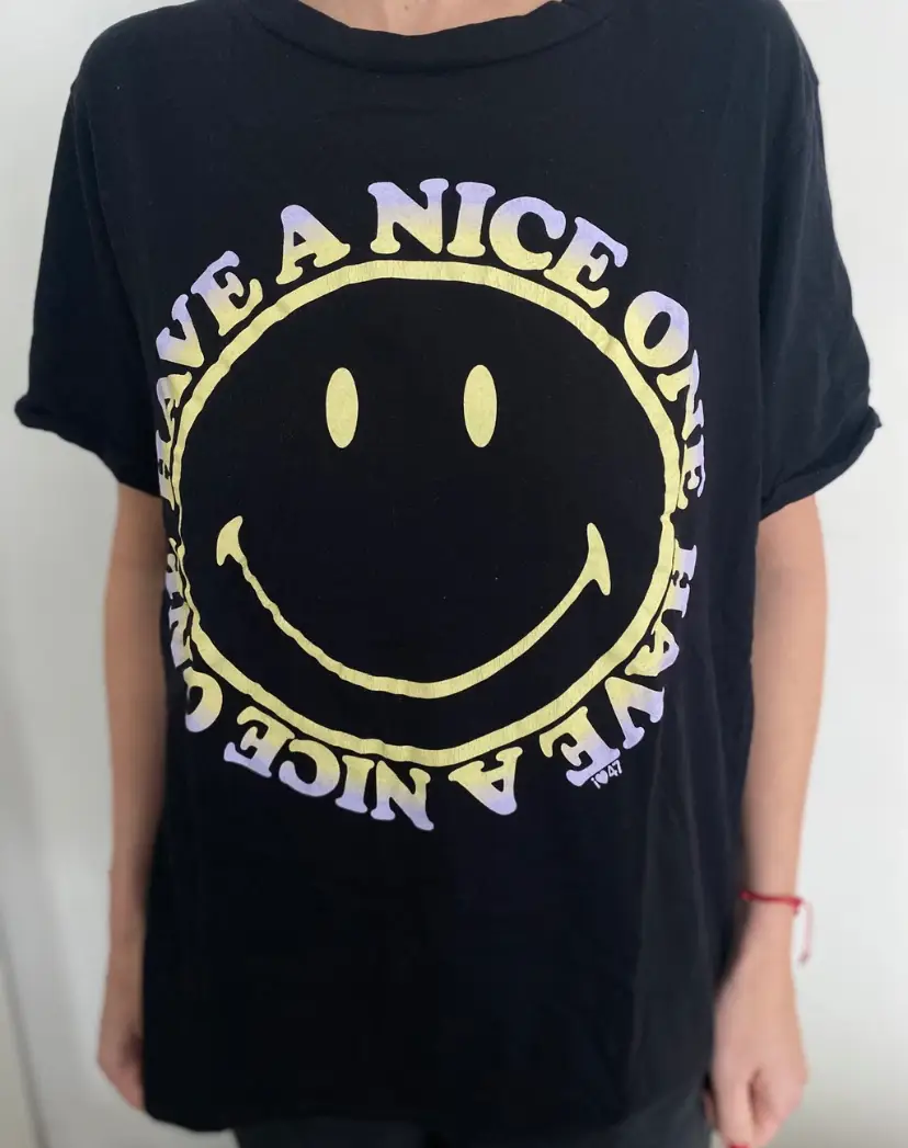 Remera negra con estampado de carita feliz y frase "Have a nice one". Ideal para un look casual y relajado. Talle 2/40.