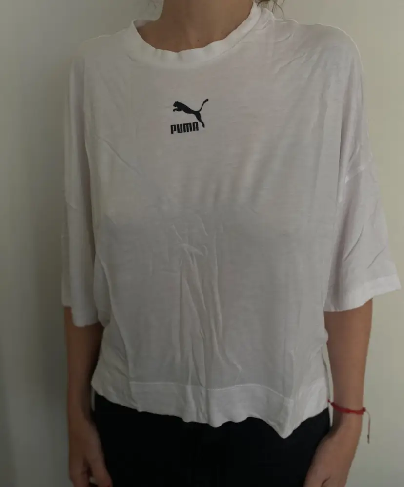 Remera Puma blanca de mujer, con logo estampado en el pecho. Talle M. Ideal para un look casual y deportivo.