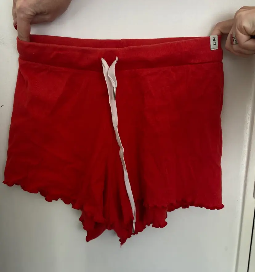 Shorts de mujer rojos, tiro alto, con cintura elastizada y detalle de volados en el borde. Ideal para un look casual y cómodo.