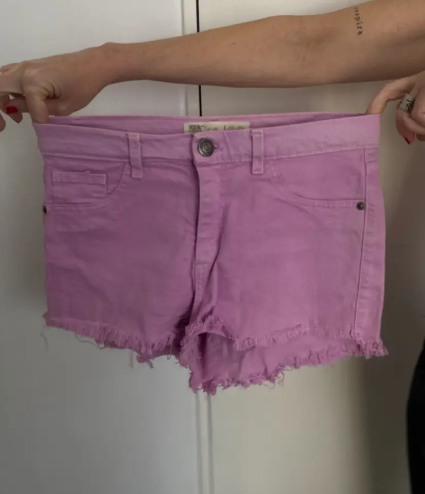 Short de jean tiro alto color rosa con flecos en el borde. Talle 42/26. Ideal para un look casual y fresco.