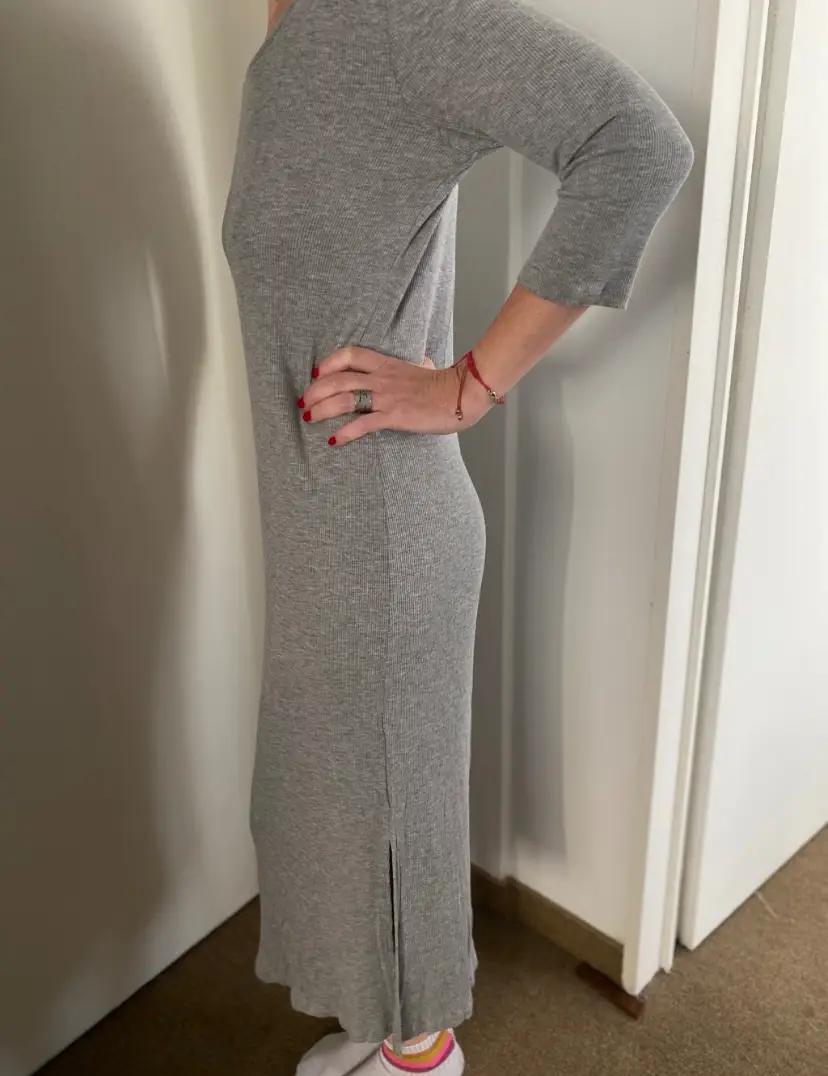 Vestido midi de punto acanalado en color gris. Corte ajustado que realza la figura, con mangas 3/4 y abertura lateral. Ideal para un look casual y cómodo.