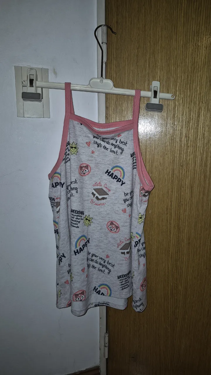 Musculosa súper tierna con estampa de "happy" y dibujitos de gatitos, arcoíris y soles. Ideal para estar cómoda y a la moda.