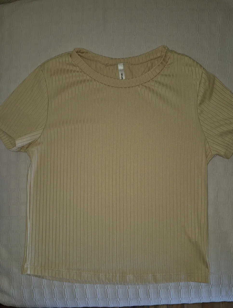 Remera de manga corta, escote redondo y textura acanalada. Un básico canchero y cómodo, ideal para el día a día.