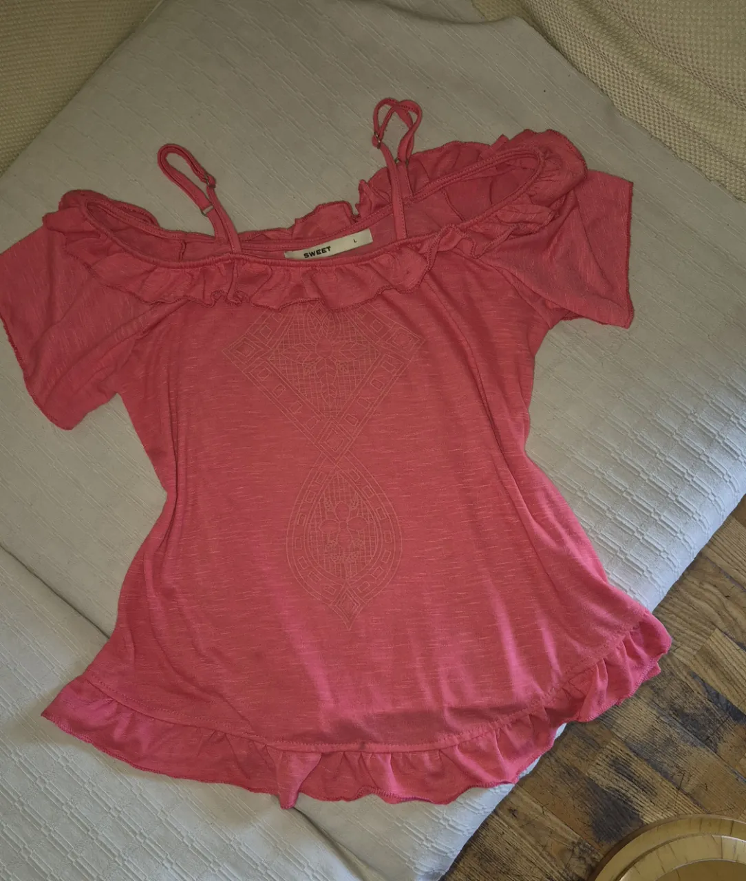 Remera súper canchera con volados y tiras finas. Tiene un estampado central y es ideal para un look relajado y a la moda.