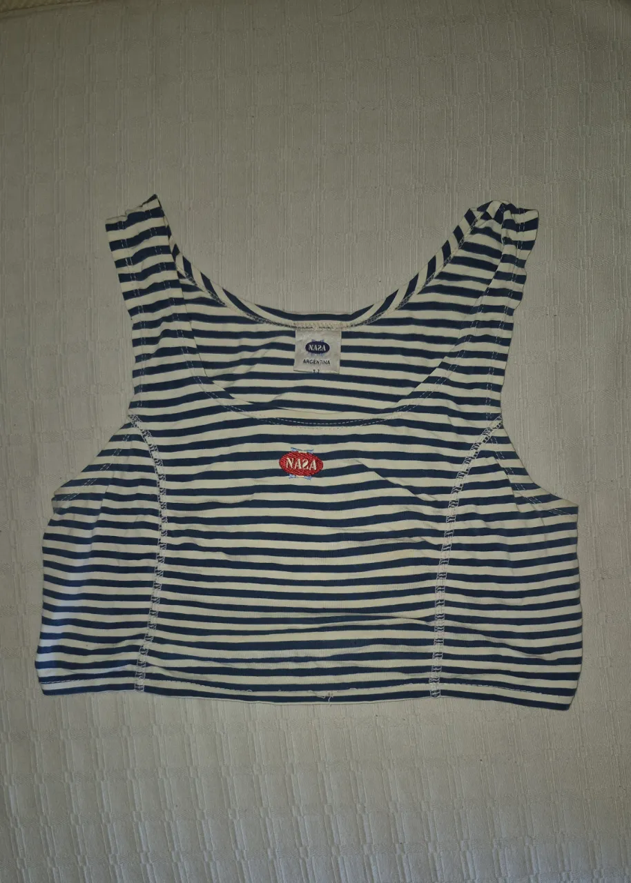 Musculosa a rayas azules y blancas, con logo de la marca bordado en el frente. Ideal para un look casual y fresco.