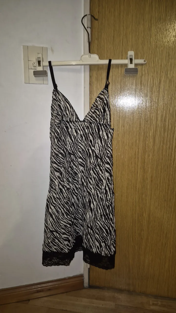 Vestido camisero con estampa animal print de cebra en blanco y negro. Posee breteles finos regulables y detalles de encaje en el ruedo. Ideal para un look canchero y sensual.