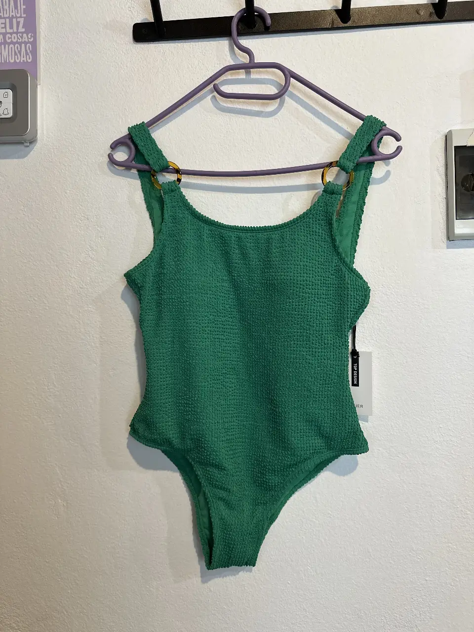 Traje de baño enterizo verde, con textura tipo waffle. Breteles con detalles dorados y corte cavado. Ideal para la playa o pileta.