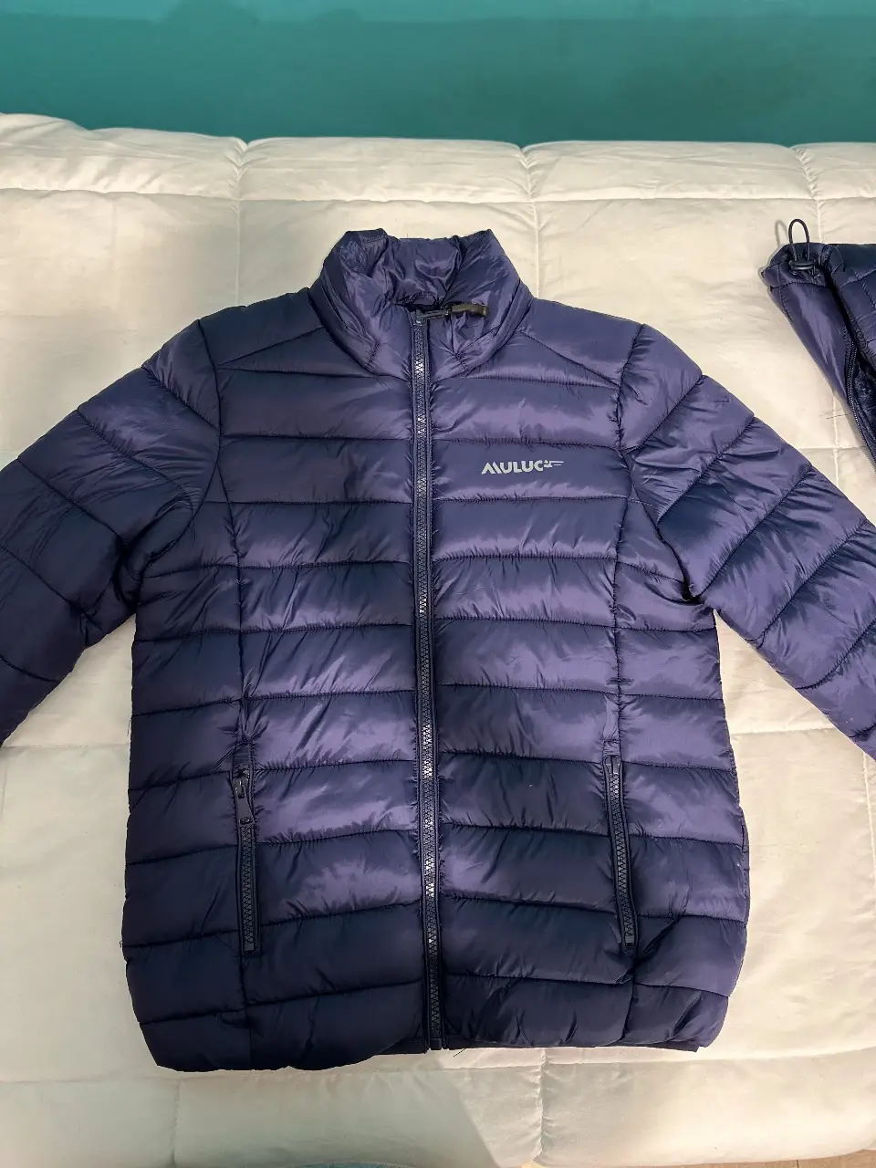 Campera de pluma azul marino para niño, ideal para el invierno. Con cierre frontal, bolsillos y el logo de la marca. Perfecta para un look casual y abrigado. MULUC