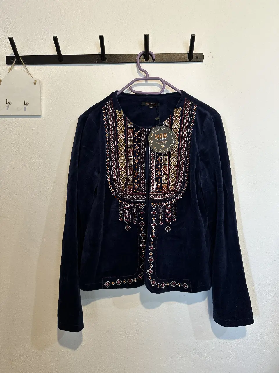 Chaqueta de terciopelo azul marino con bordado en el pecho y detalles en los bordes. Estilo boho chic, ideal para un look elegante y con personalidad. Marca NRE New Story.