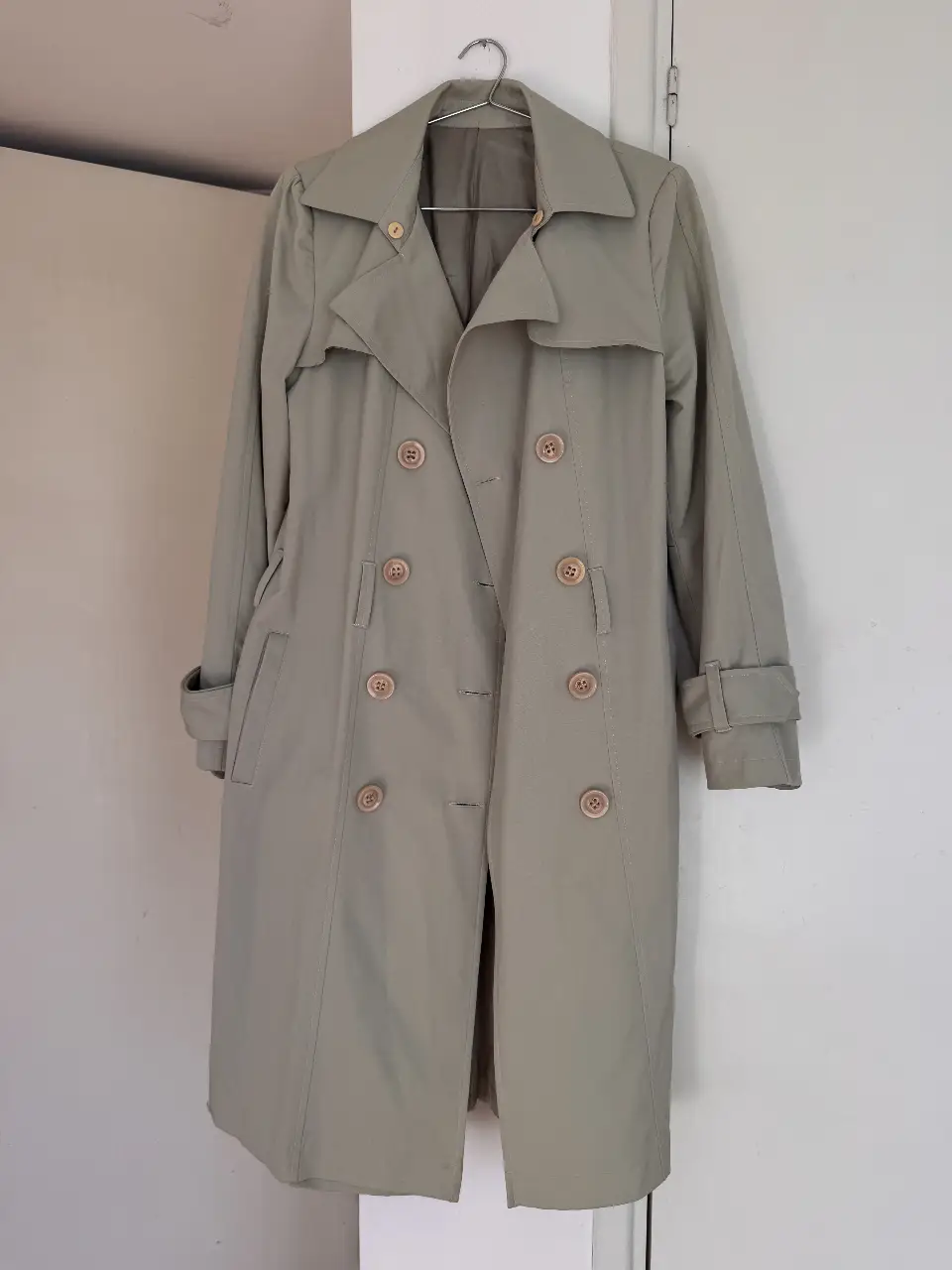 Trench coat verde claro, estilo clásico con doble botonadura y cinturón. Ideal para un look elegante y atemporal.