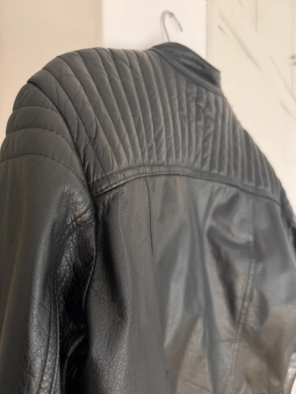 Campera de cuero negra para hombre, estilo rock con detalles acolchados en hombros y espalda. Cierre y bolsillos con cremallera. Ideal para un look moderno y urbano.