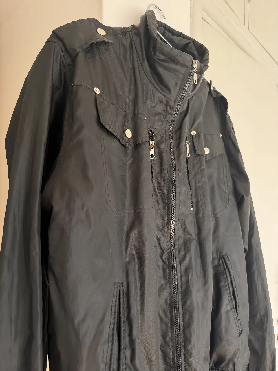 Campera bomber negra con detalles de diseño. Ideal para un look casual y moderno. Con cierre y bolsillos funcionales.