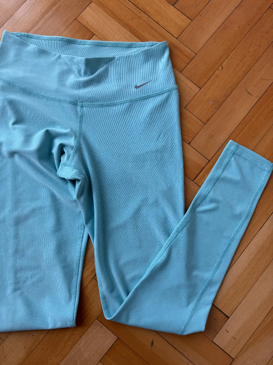 Calzas deportivas Nike de color celeste, talle S, ideales para actividades físicas. Confeccionadas en material ligero y transpirable, perfectas para entrenamientos.