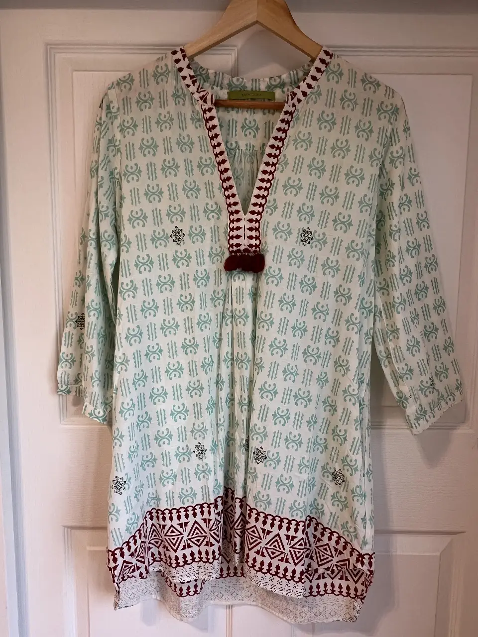 Blusa estampada de manga 3/4 con detalles bordados en el cuello y el bajo. Estilo boho, ideal para un look casual y fresco.