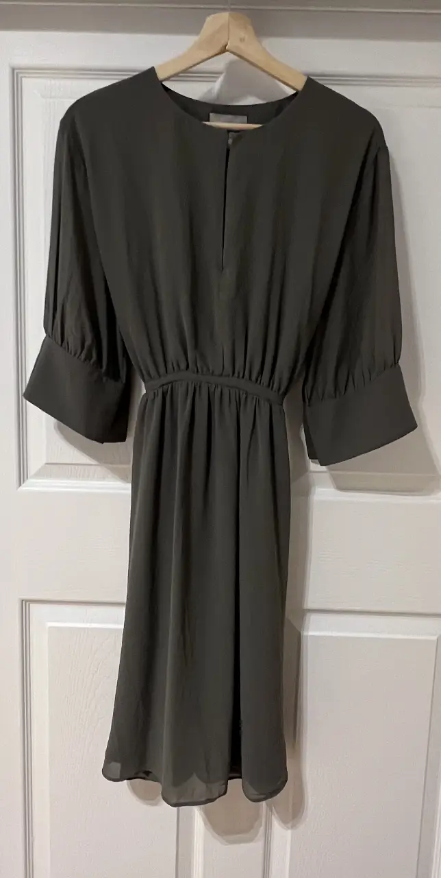 Vestido midi de color verde oscuro, con mangas 3/4 y cintura entallada. Ideal para un look elegante y versátil.
