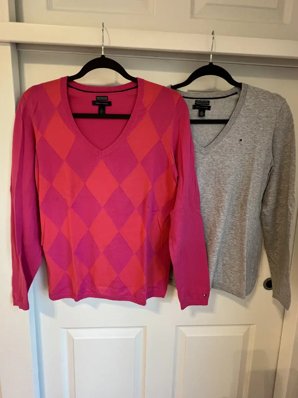 Sweater Tommy Hilfiger de mujer con diseño de rombos en tonos rosa y naranja. Cuello en V y manga larga. Ideal para un look casual y abrigado.