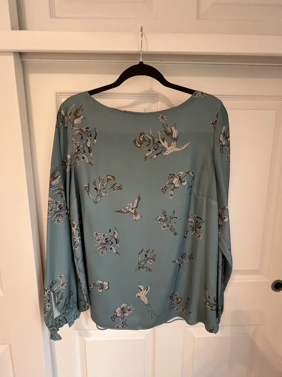 Blusa celeste con estampado floral y de aves, manga larga con puños y cuello redondo. Ideal para un look casual y elegante.