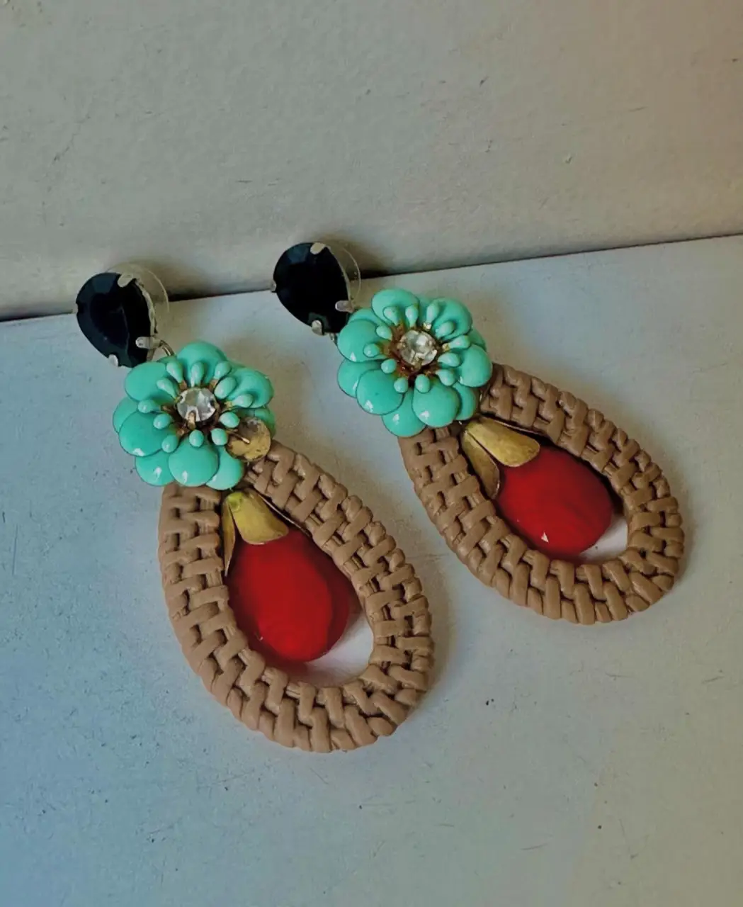 Aros colgantes artesanales con diseño floral y detalles en rojo y beige. Ideales para darle un toque bohemio y original a tu look. Marca: Vados del Isen