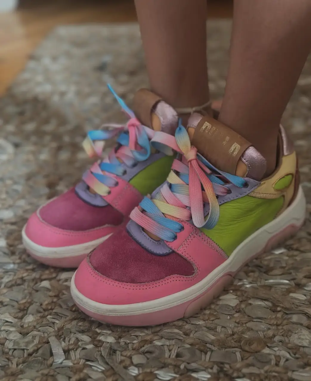 Zapatillas deportivas multicolores para niña, con cordones arcoíris y detalles en rosa y amarillo. Ideales para un look casual y divertido.