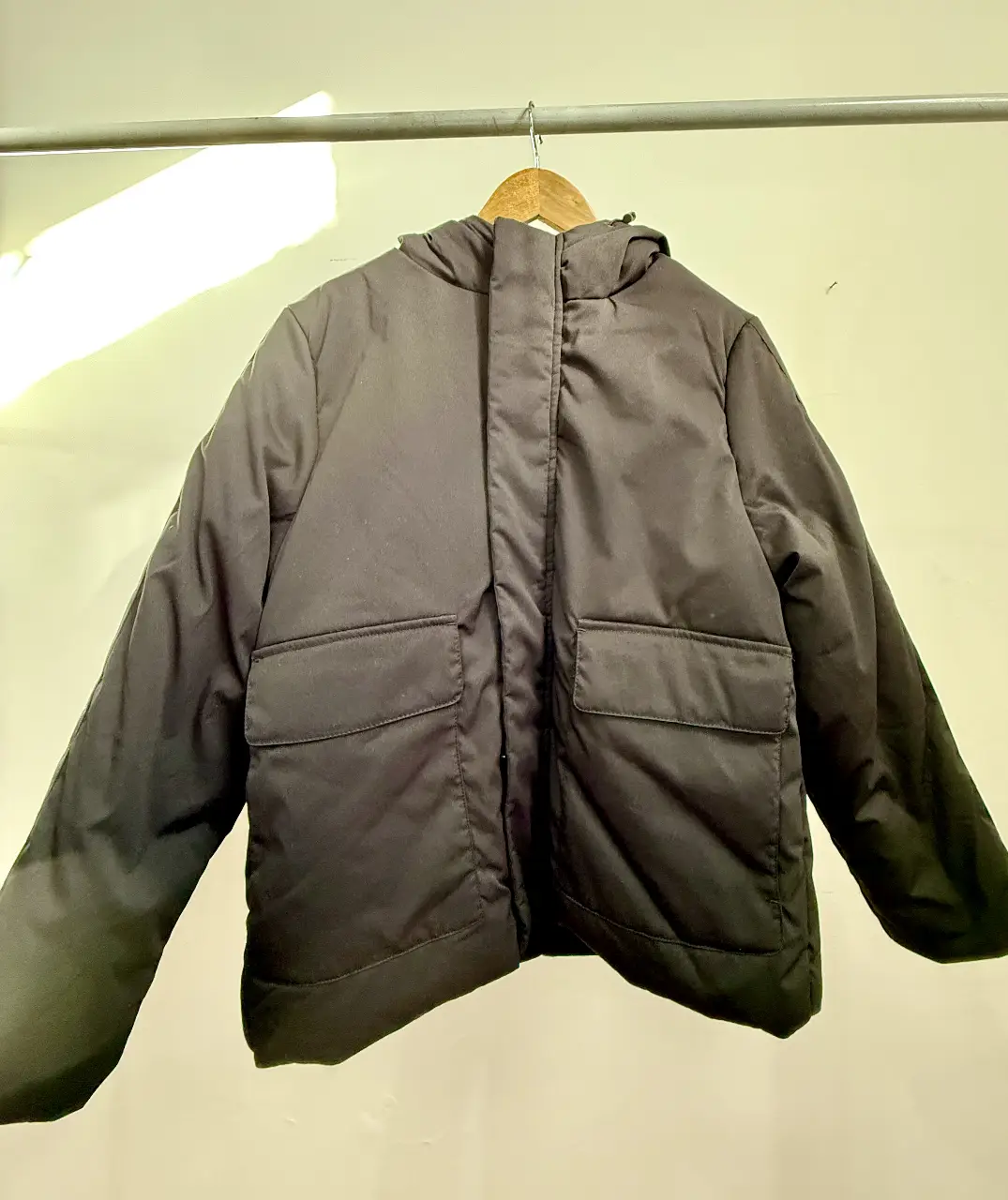 Campera negra con capucha Ossira, ideal para el invierno. Cuenta con dos bolsillos delanteros amplios y cierre. Perfecta para un look casual y abrigado.