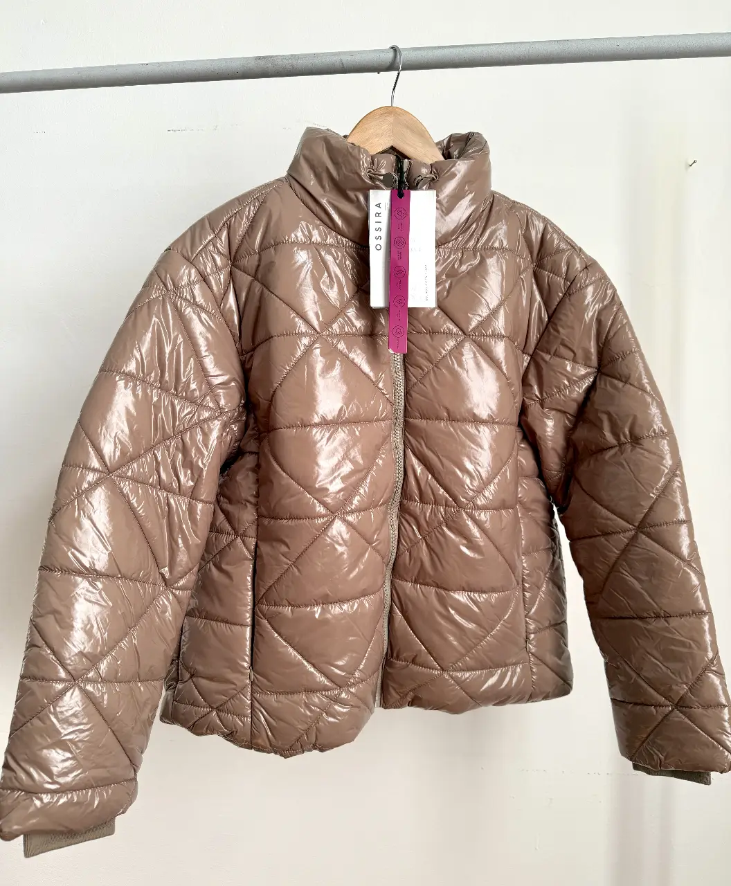 Campera puffer marrón brillante con cierre y cuello alto. Ideal para el invierno, con un diseño acolchado y un estilo moderno.