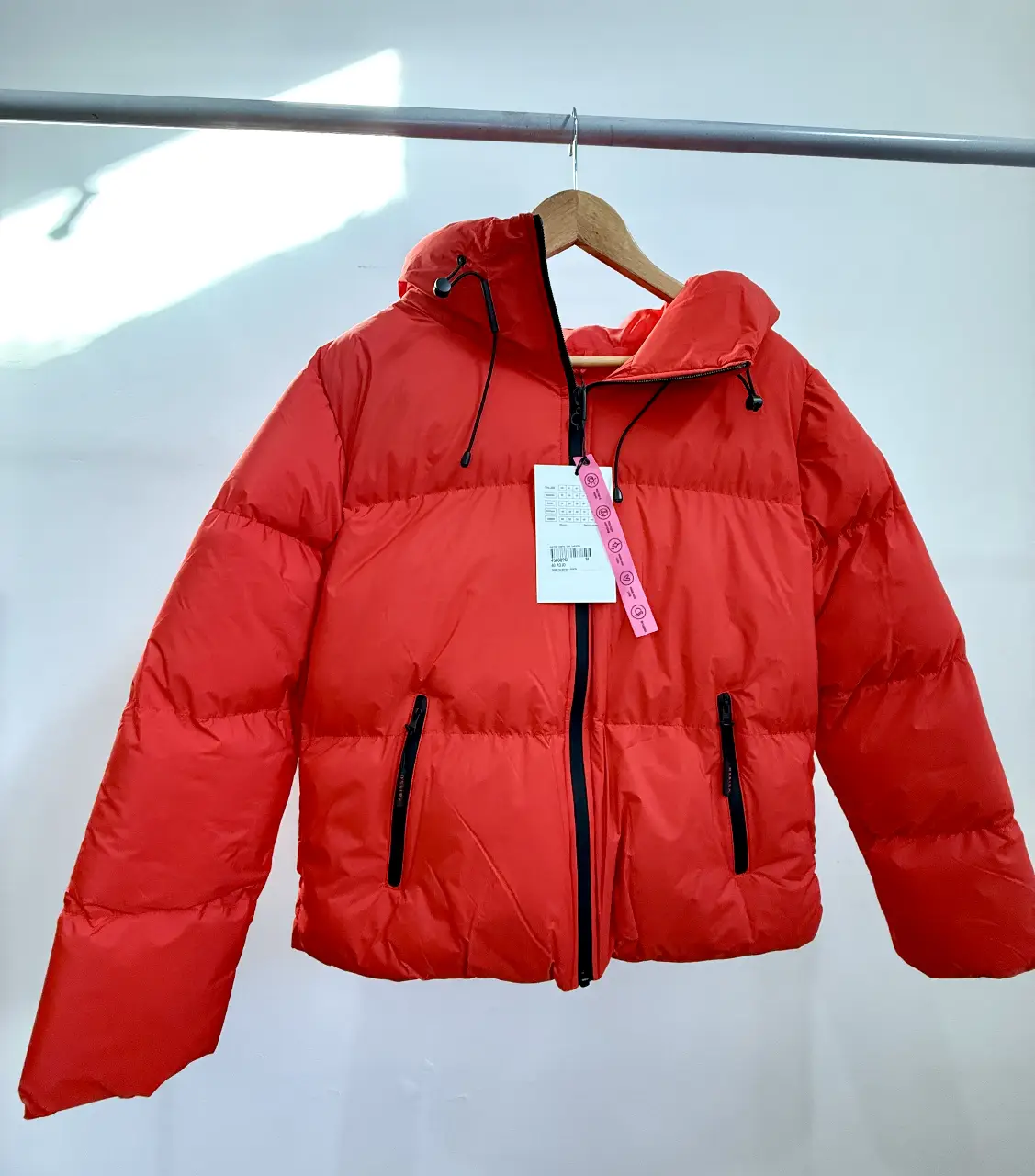 Campera puffer roja con capucha Ossira, ideal para el invierno. Cuenta con cierre frontal y bolsillos con cierre. Perfecta para un look casual y abrigado.