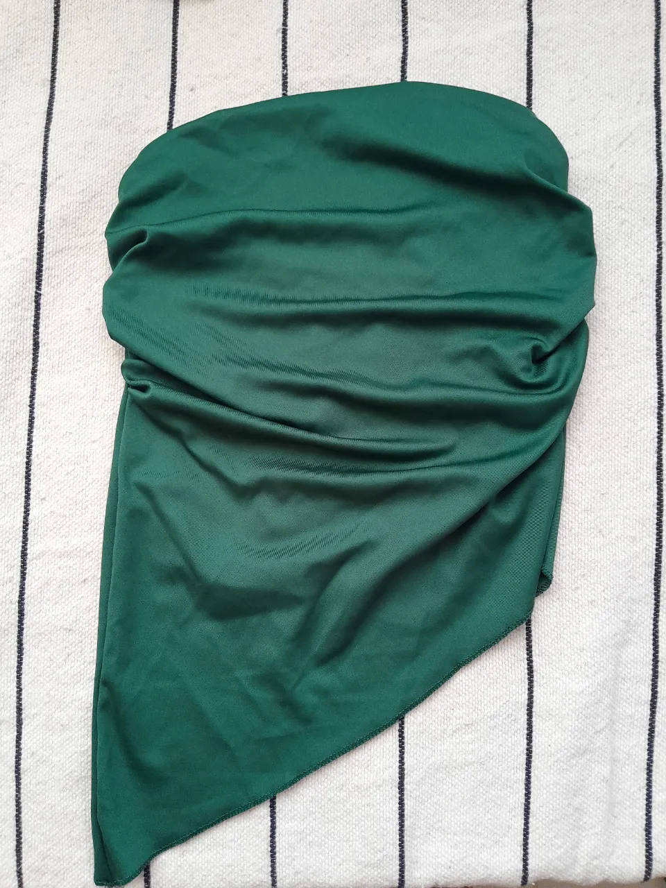 Top verde con fruncido lateral y detalle de elástico en la espalda.