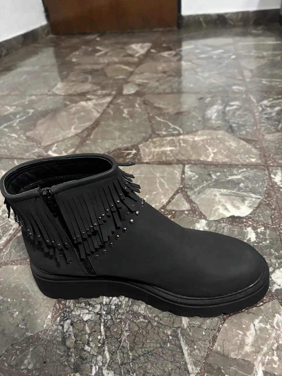 Botines negros con flecos y detalles de tachas. Ideales para un look moderno y canchero.