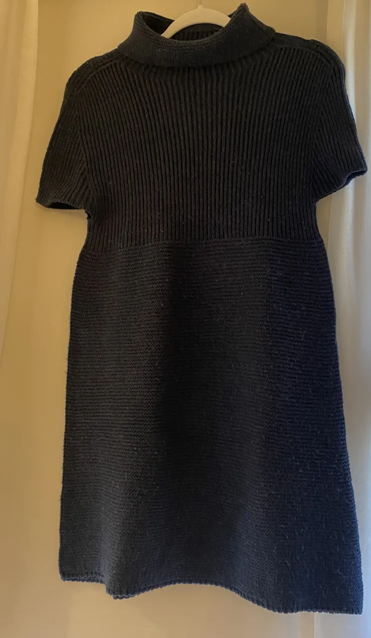 Vestido tejido de cuello alto y mangas cortas. Diseño acanalado en la parte superior y liso en la falda. Ideal para un look casual y abrigado.