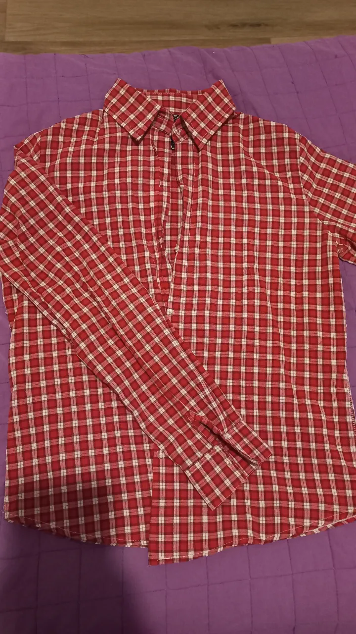 Camisa a cuadros roja y blanca de manga larga, ideal para un look casual y versátil. Perfecta para combinar con jeans o pantalones chinos.