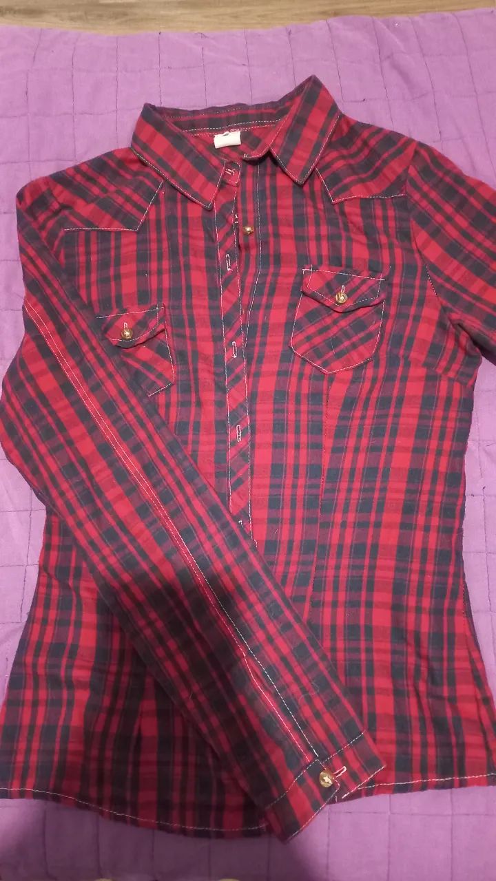 Camisa a cuadros roja y negra de manga larga, estilo leñador, ideal para un look casual y moderno.