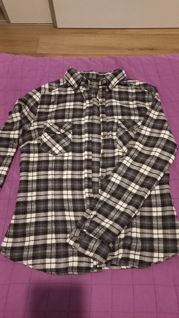 Camisa a cuadros en blanco y negro, ideal para un look casual y versátil. Perfecta para combinar con jeans o pantalones de vestir.