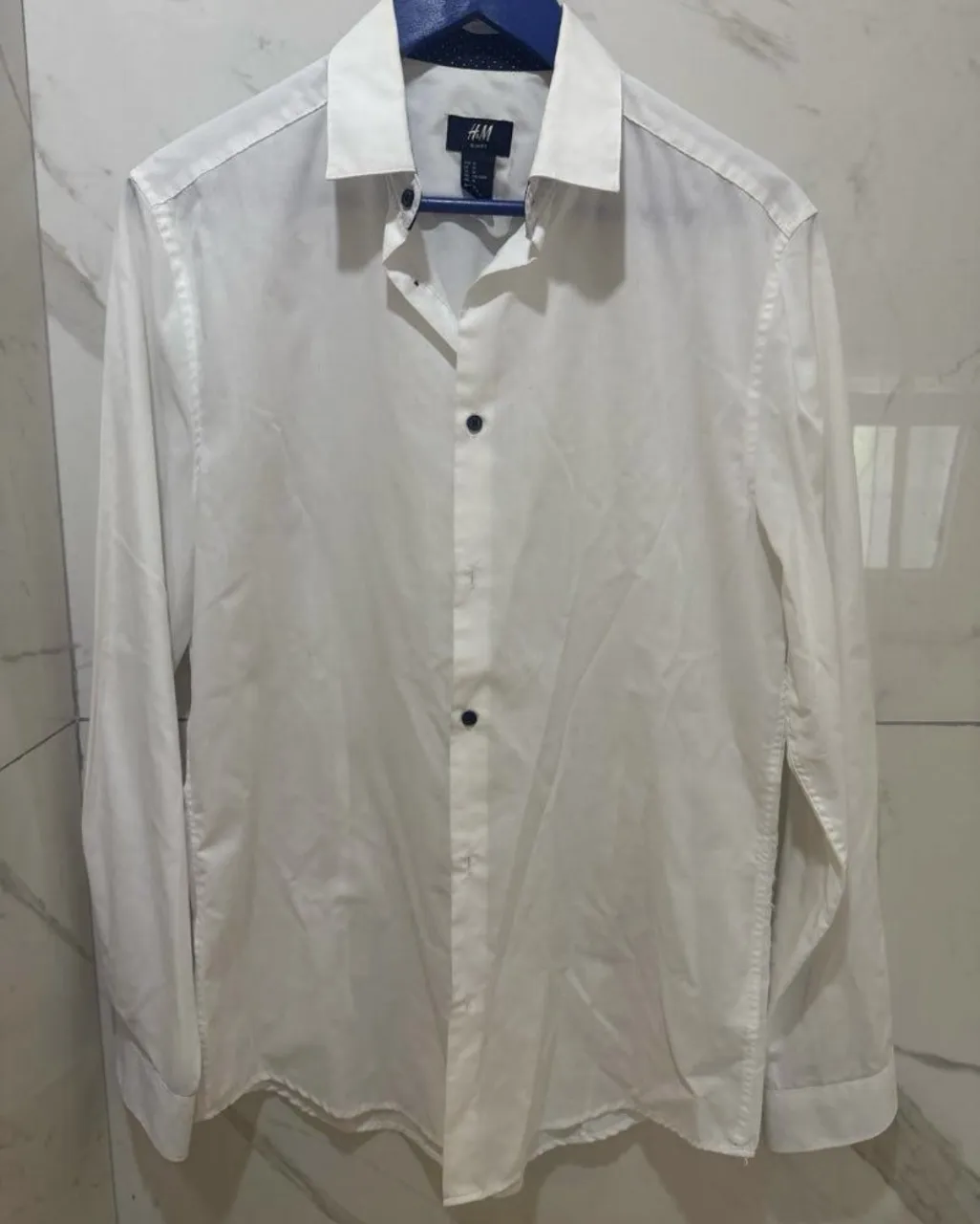 Camisa blanca de vestir H&M, corte slim fit. Perfecta para un look elegante y formal, ideal para el trabajo o eventos especiales. Su diseño clásico la hace súper versátil.