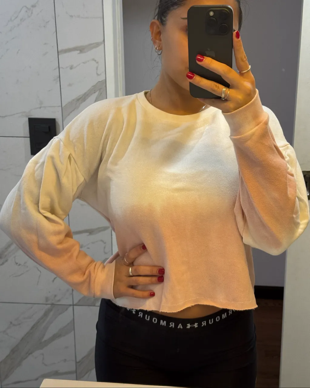 Buzo crop con degradado de blanco a rosa pálido. Mangas largas y cuello redondo.