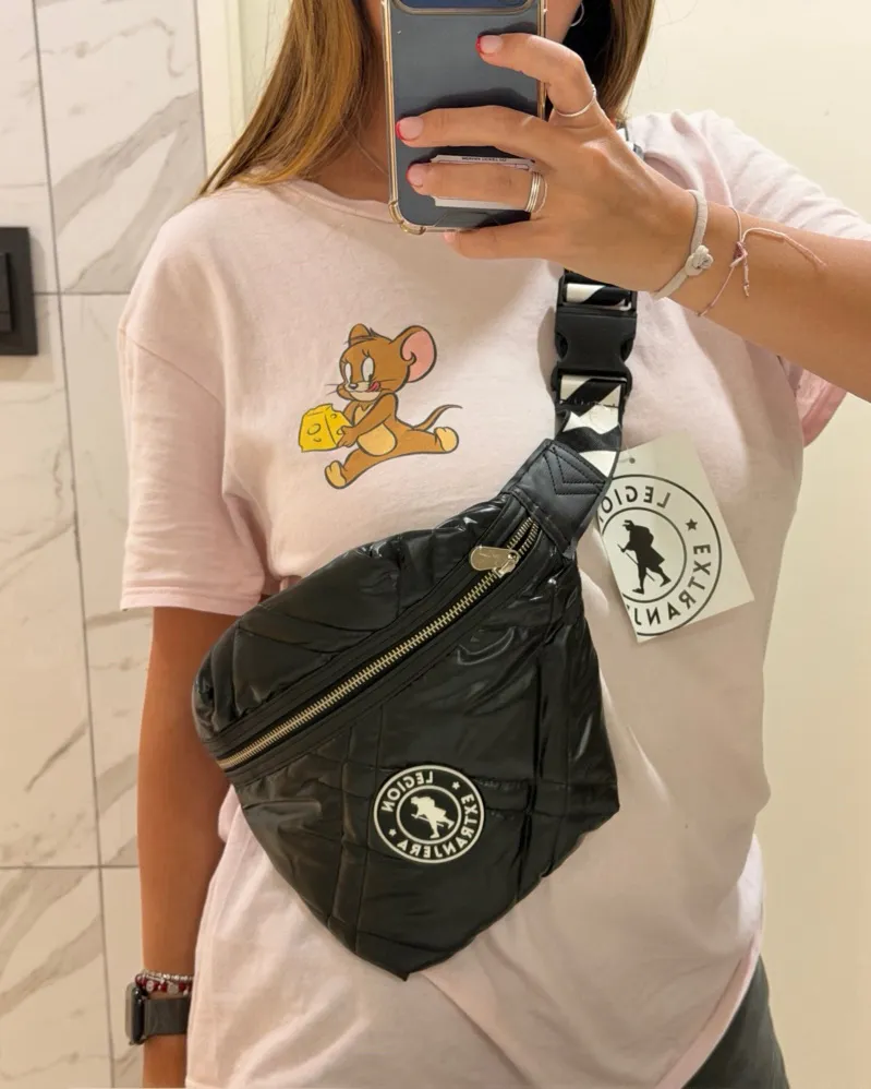 Riñonera negra acolchada, súper canchera y práctica. Ideal para llevar tus esenciales con estilo. Posee correa ajustable con detalles de cebra y logo.