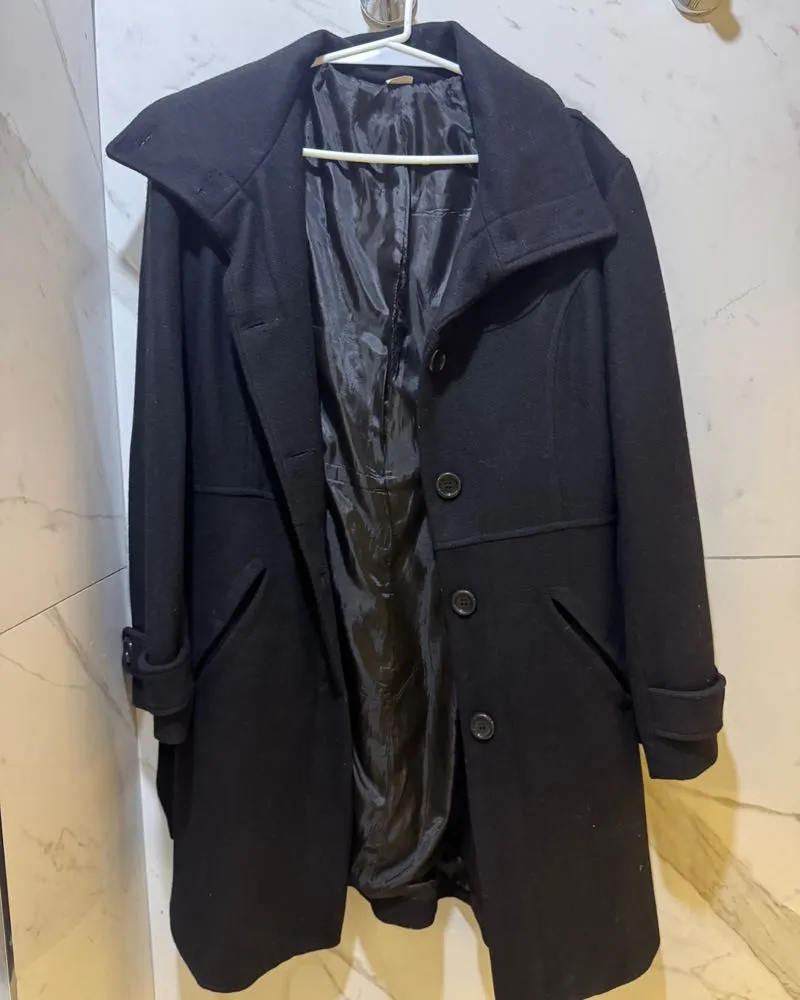 Abrigo negro largo con cinturón, ideal para el invierno. Elegante y versátil, perfecto para cualquier ocasión.