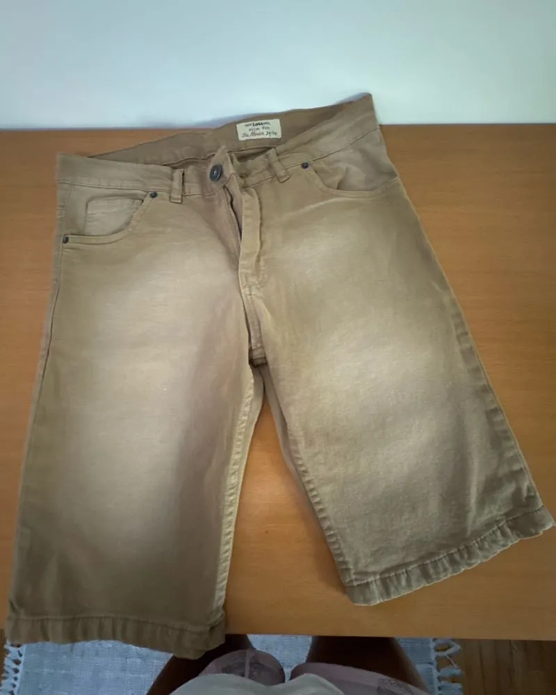 Shorts de gabardina color tiza. Posee bolsillos delanteros y traseros. Cierre y botón en la parte frontal.