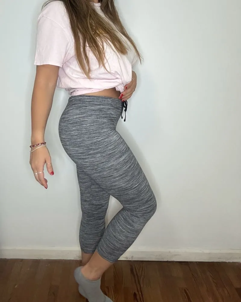 Calza deportiva gris jaspeada, tiro alto, con cordón ajustable en la cintura. Perfecta para entrenar o para un look casual y cómodo.