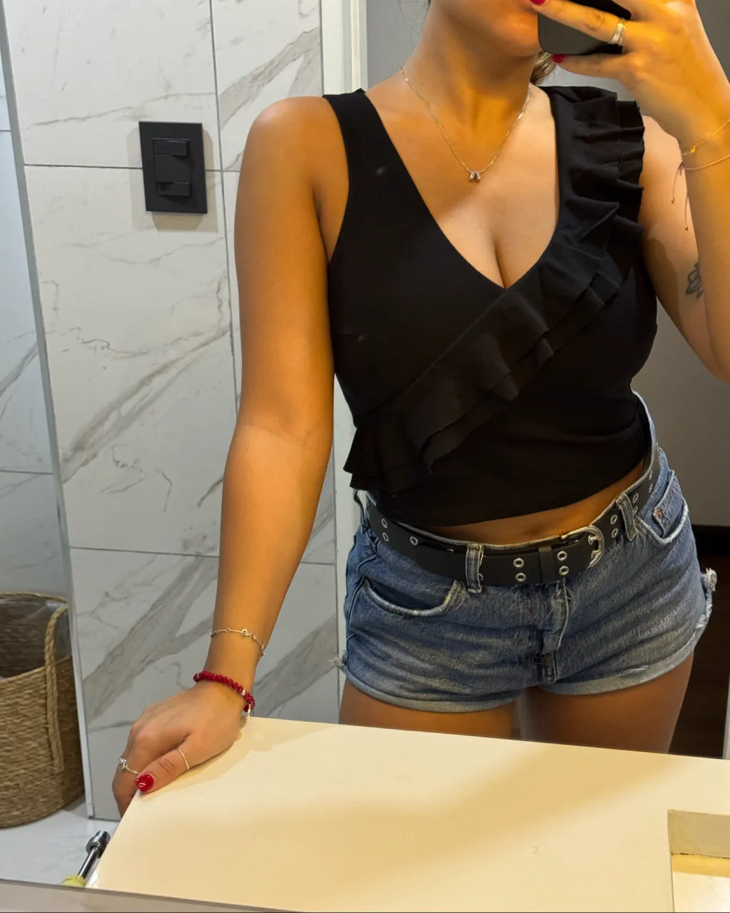 Top negro con volados en el escote y un bretel.