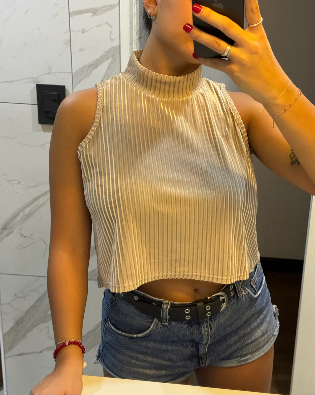 Top sin mangas con cuello alto y textura acanalada. Diseño corto.