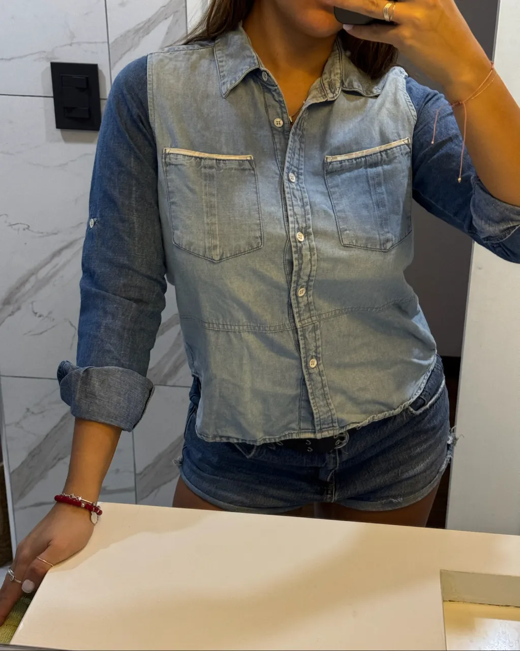 Camisa de jean de manga larga con dos bolsillos delanteros y botones. Se puede usar con las mangas arremangadas.