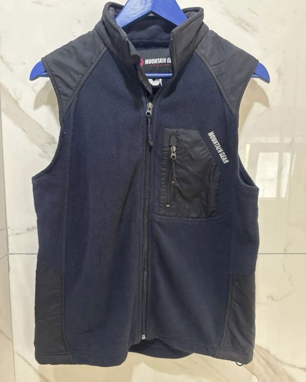 Chaleco de abrigo de micropolar azul marino con detalles en negro. Posee cuello alto, cierre completo al frente y bolsillos con cierre. Ideal para actividades al aire libre o para un look casual y abrigado.