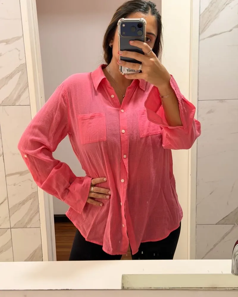 Camisa rosa de manga larga con botones al frente y dos bolsillos en el pecho. Perfecta para un look casual y cómodo.
