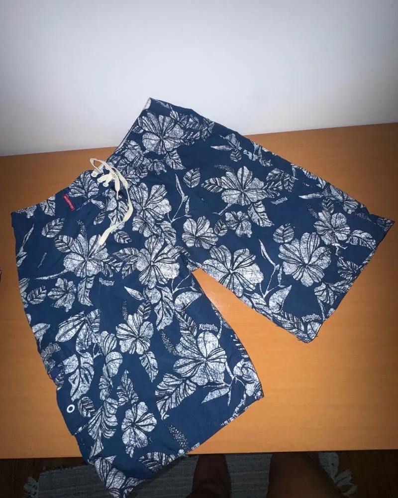 Shorts de baño estampados con flores en azul marino y blanco. Tienen cordón para ajustar en la cintura.