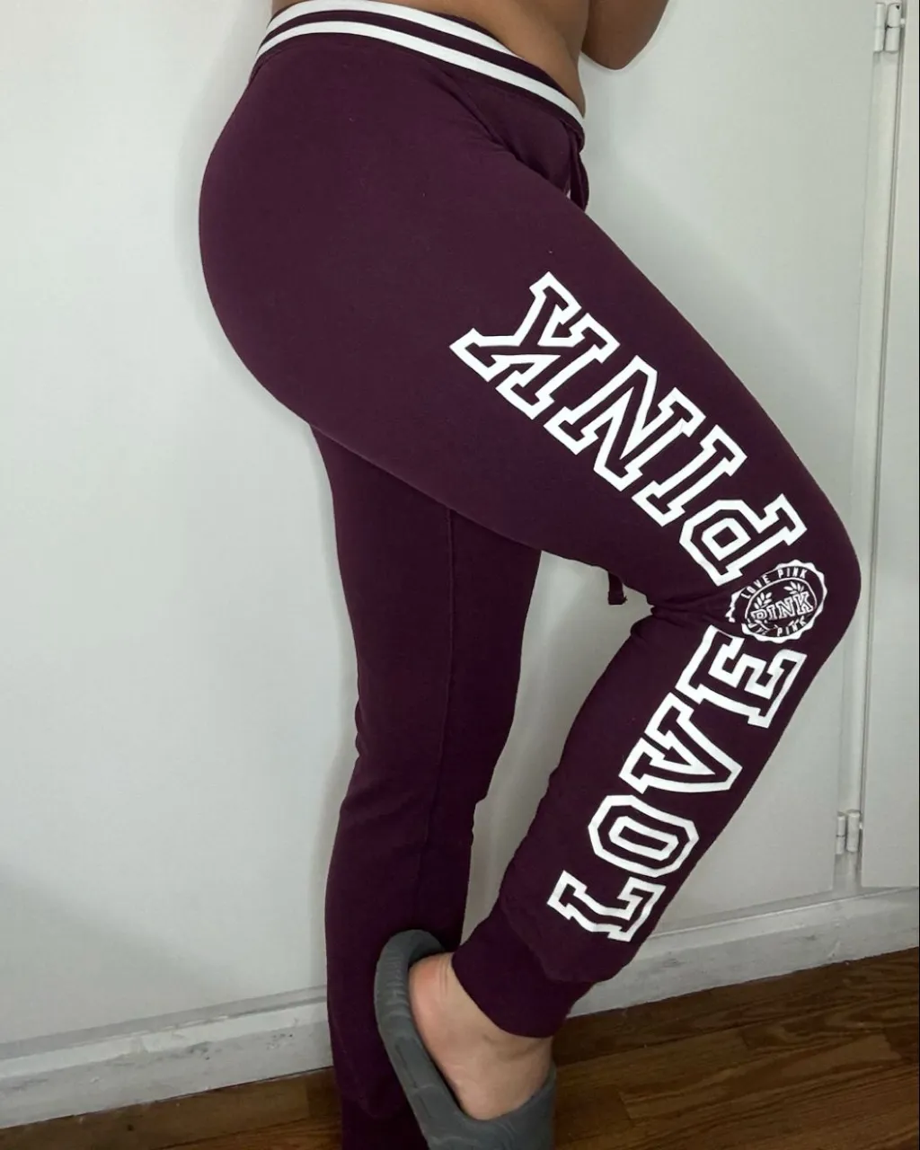 Pantalón de algodón color bordo con franjas blancas en la cintura y puños. Estampado blanco en la pierna izquierda con la inscripción "PINK" y "LOVE PINK". Cordón ajustable en la cintura.