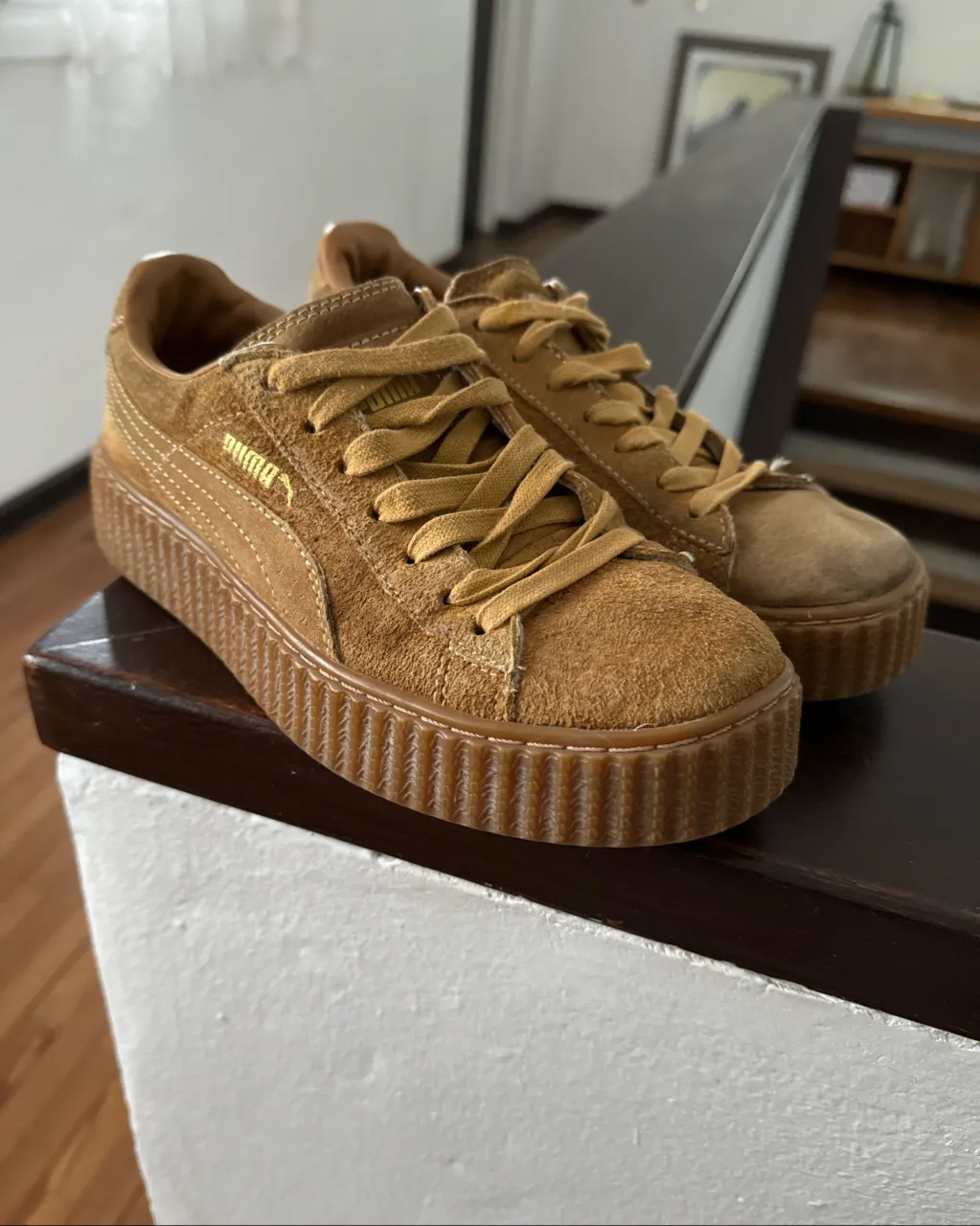 Zapatillas de gamuza color marrón claro con cordones. Tienen una suela gruesa y acanalada. La marca se ve en el lateral y en la suela.