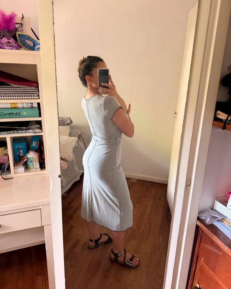 Vestido midi gris con detalles de costura y cinturón. Ideal para un look casual y elegante.