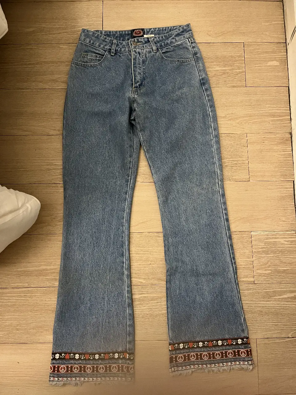 Jeans de mujer, tiro medio, corte recto con detalles bordados en los bajos. Marca Paris Blues Originals. Talle 7. Pequeña mancha en la parte trasera de la rodilla. 