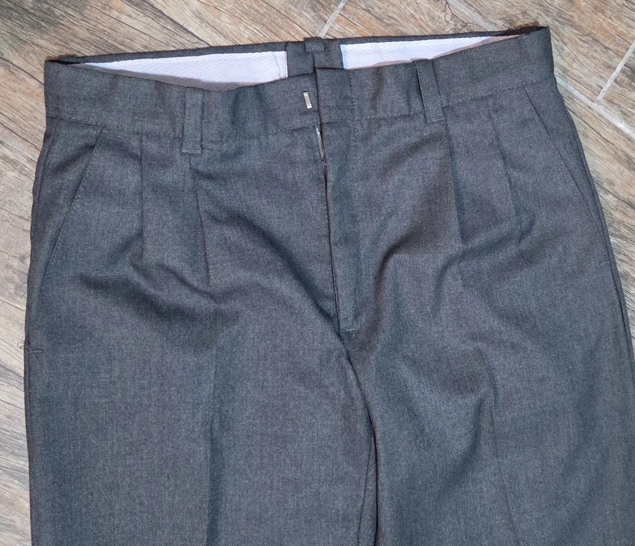 Pantalón de vestir gris, con pinzas y corte recto. Ideal colegial y para un look formal o de trabajo. Talle 42